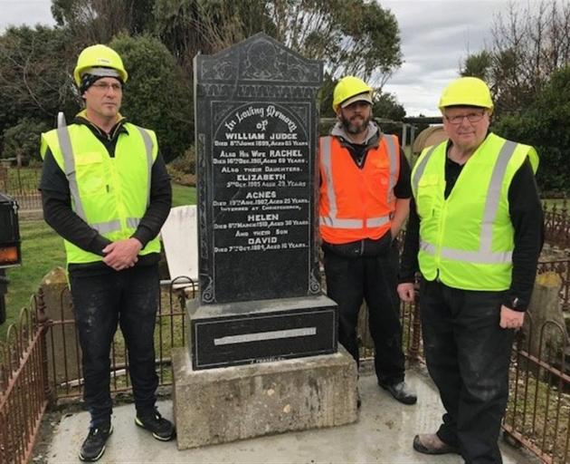 The headstone after repairs and installation were complete by Maiden Stone workers (from left)...