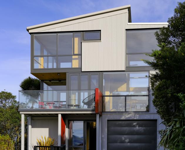 Grey cladding and window frames help the building blend in with its surroundings, while red...