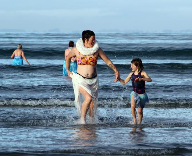 Splashing their way back to drier ground after taking part in the Riverton midwinter swim at...