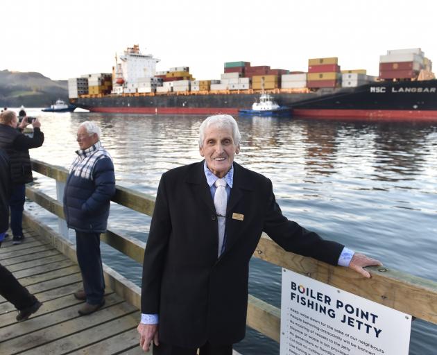 Warren Lewis stands on the jetty named after him as container ship MSC Langsar is guided past....