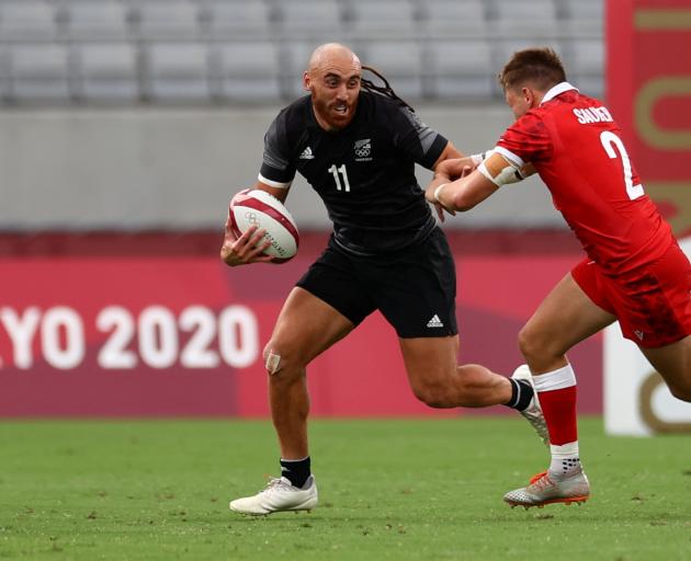 New Zealand's Joe Webber fends off a tackle from Canada's Theo Sauder on  Tuesday. Photo: Reuters 