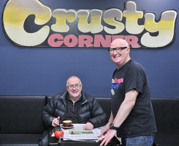 Crusty Corner owner Rob Barker (standing) serves regular customer Geoff Oswald yesterday. PHOTO:...