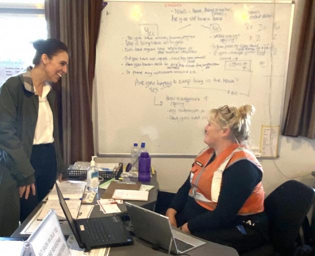 Prime Minister Jacinda Ardern (left) speaks with a volunteer at the Buller Emergency Management...