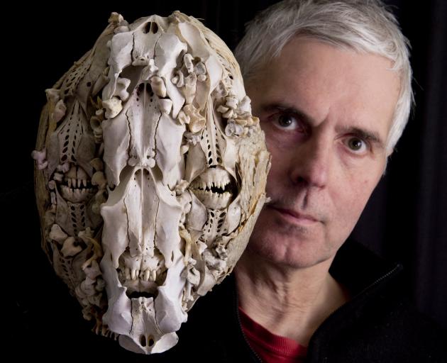 Showing off  a previous work, a bone collage mask, is Dunedin artist and World of WearableArt...