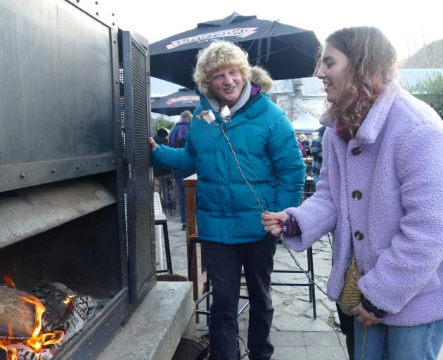 Emma Morton-Farrelly (19), of Mount Maunganui, keeps herself warm while toasting marshmallows...