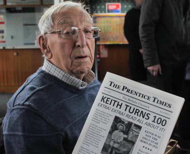 Keith Prentice shows the newspaper made by his family about his life to celebrate his 100th...