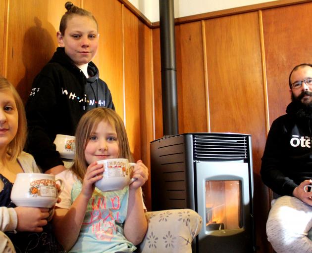 Enjoying the heat from their new fire from Otago Pellet Fires are Lillian (8), Ben (12) and...