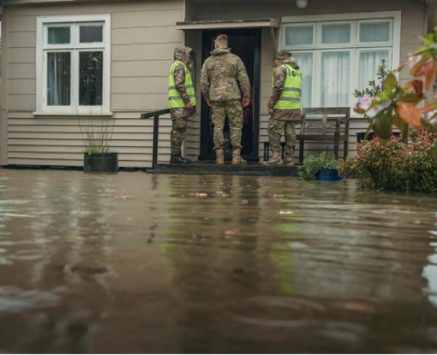 Defence Force staff visit a house affected by floodwaters. Photo: Defence Force