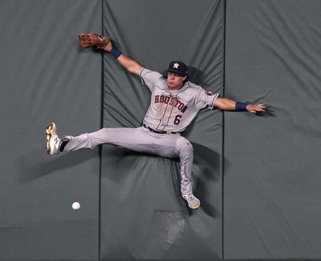 Houston Astros outfielder Jake Meyers hits the wall as he attempts to catch the ball against the...