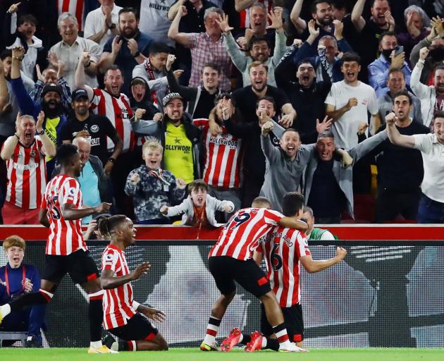 Brentford fans and players celebrate their second goal against Arsenal to kick off their first...
