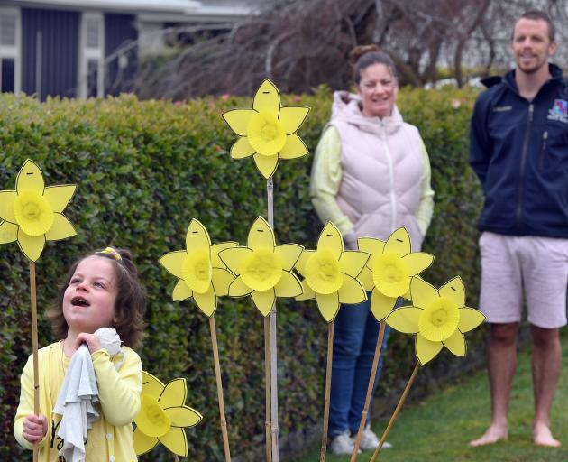 Esme Palmer  checks out a plywood daffodil outside her Balclutha home, while her mother Megan...