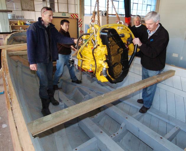 Guiding a diesel engine into place are (from left) Scott Broere, Shem Sutherland,
...
