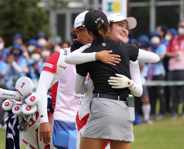 Lydia Ko (in black) embraces Mone Inami after the tense playoff for silver in Tokyo. Photo: Getty...
