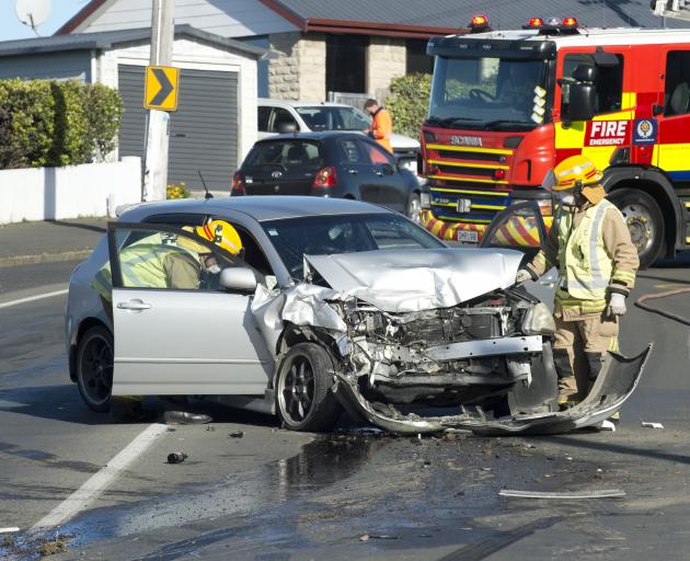 Dunedin firefighters inspect the vehicle left at the scene of a crash at The Glen Saturday....