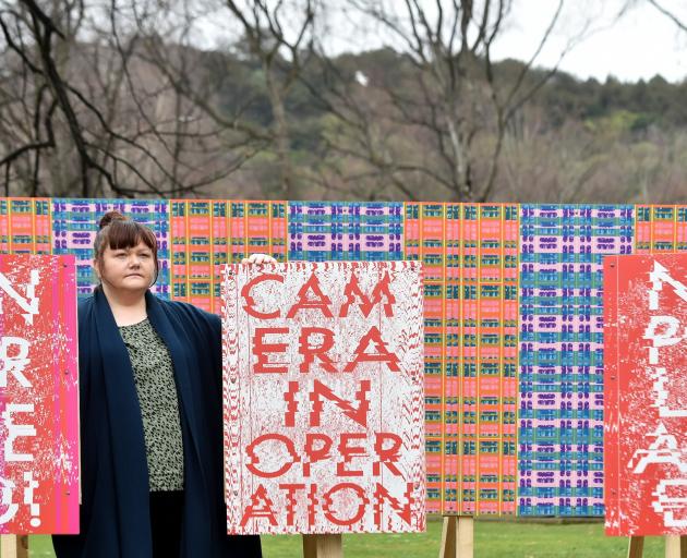 Masters student Maggie Covell stands beside her billboard wallpaper installation at the Otago...