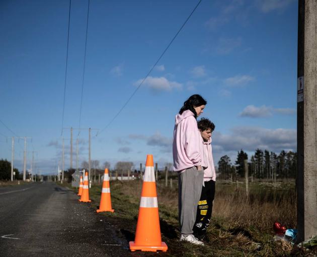 Friends of the victims paying their respects at the scene. Photo: George Heard