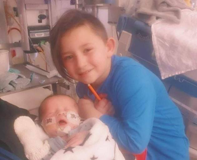 Little Keanu-Jay Brown is surrounded by his family at Starship Hospital including his big brother...