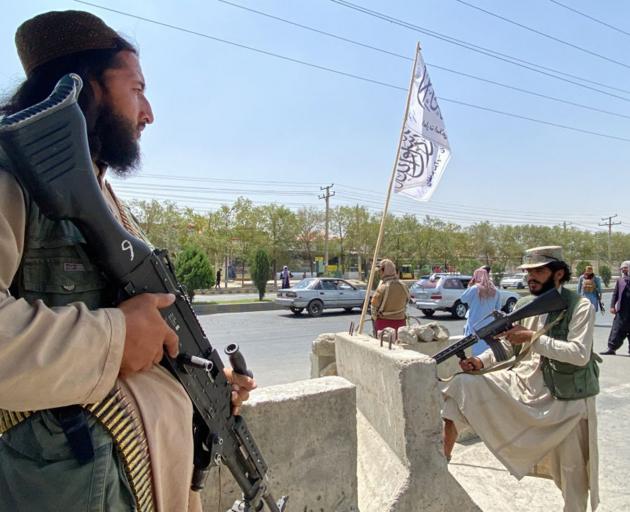 Taliban fighters stand guard at an entrance gate outside the Interior Ministry in Kabul this week...