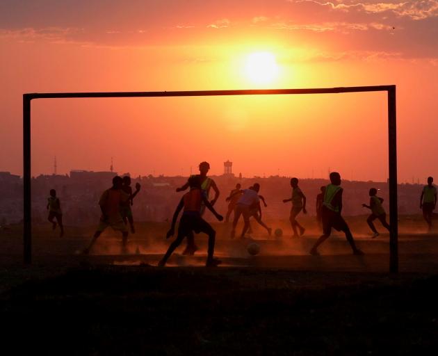 Locals play football on a dusty pitch in Soweto, South Africa. REUTERS
