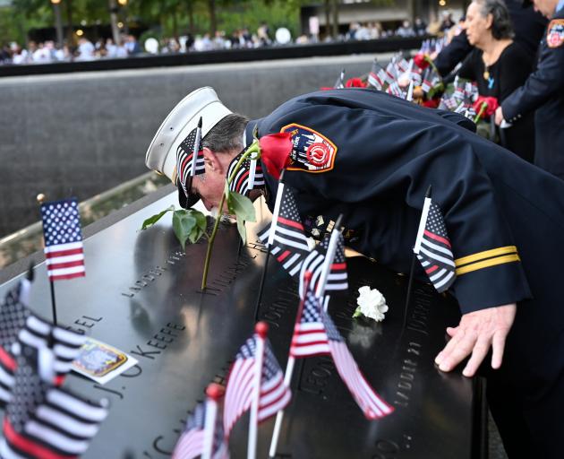 Retired Paramedic Chief Charlie Wells kisses the name of a relative killed in the attack on the...