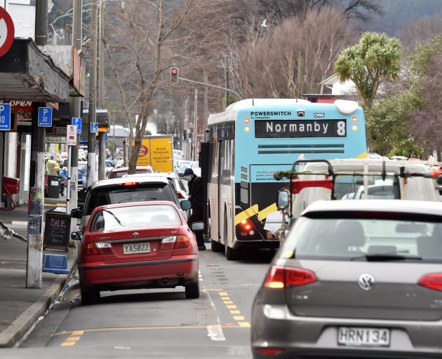 A bus parks in the street to pick up passengers at a bus stop on North Rd near the Dunedin...