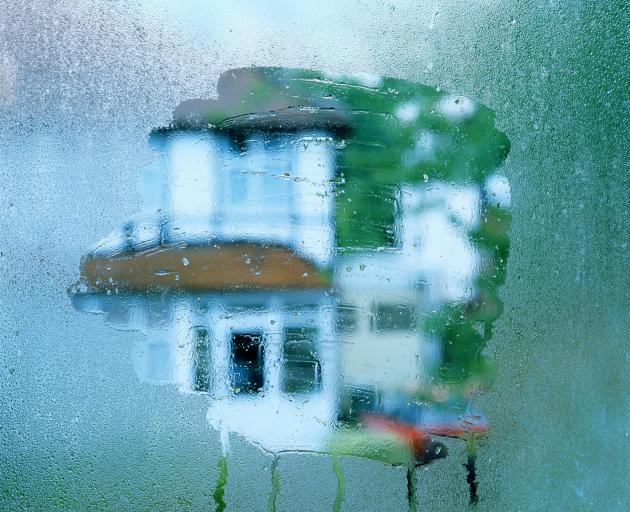 Condensation on a window and a house in background. Damp home. Photo: Getty Images