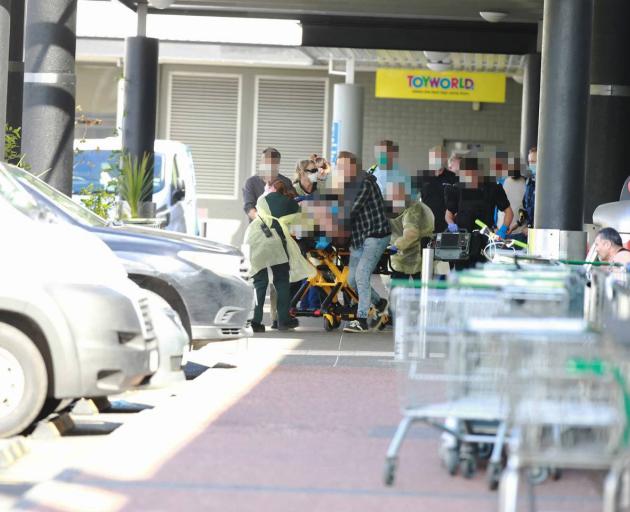 An injured shopper is rushed to an ambulance after the terrorist attack in an Auckland...