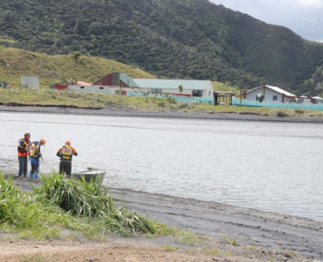 Search and rescue teams get in a dingy over the estuary at Marokopa early on Sunday afternoon,...