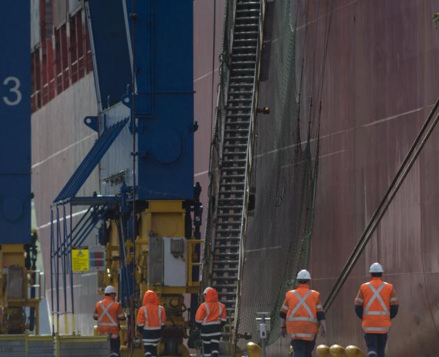 Port Otago workers beside the container ship Rio de Janeiro at Port Chalmers yesterday. All the...