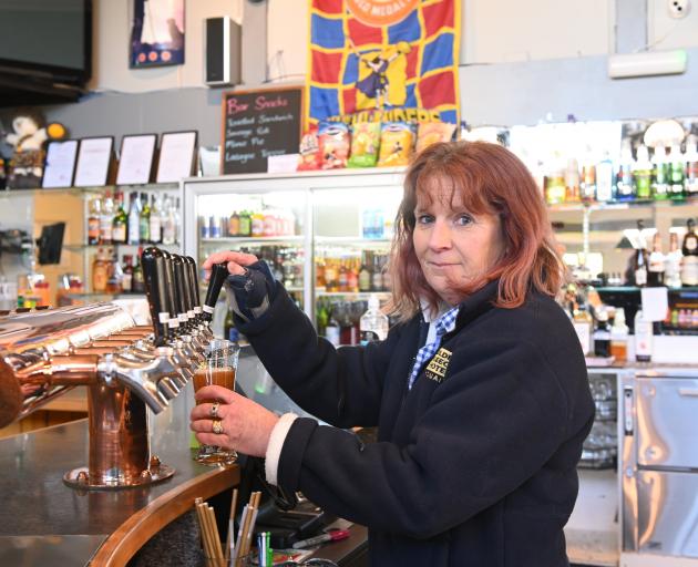 Golden Fleece Hotel and Motel co-owner Rose Cayford pours one of the first drinks after the...