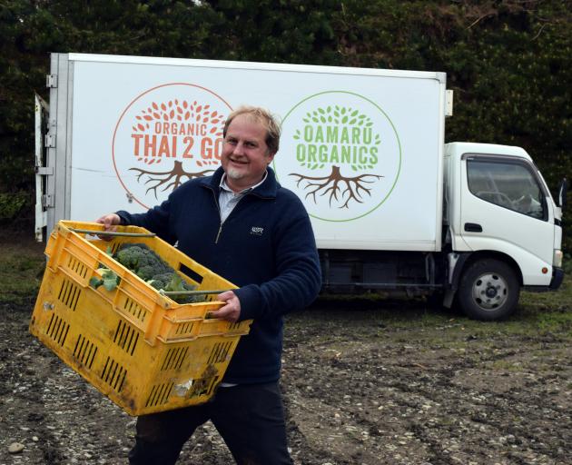 Organic Solutions director and co-founder James Porteous packs a truck with organic vegetables in...