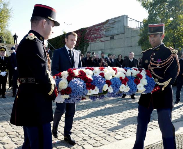 French President Emmanuel Macron (c) lays a wreath near the Pont de de Bezons, Bezons bridge,...