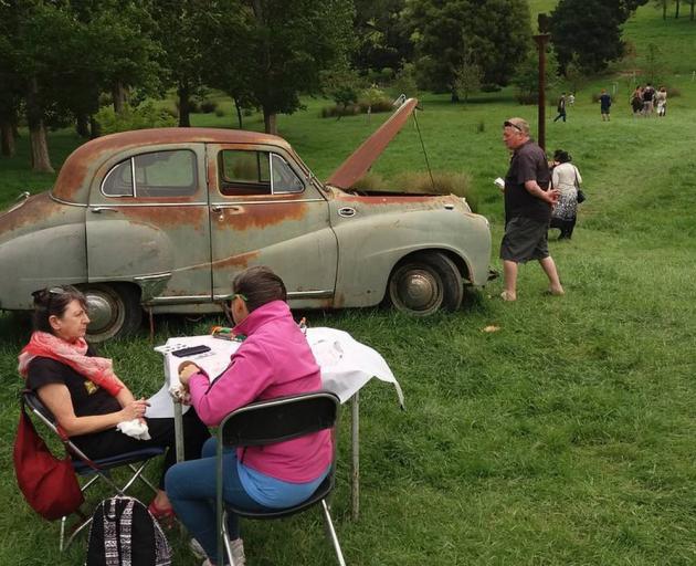 People wandering around the grounds of Loudon Farm at the Sculpture on the Peninsula event in...