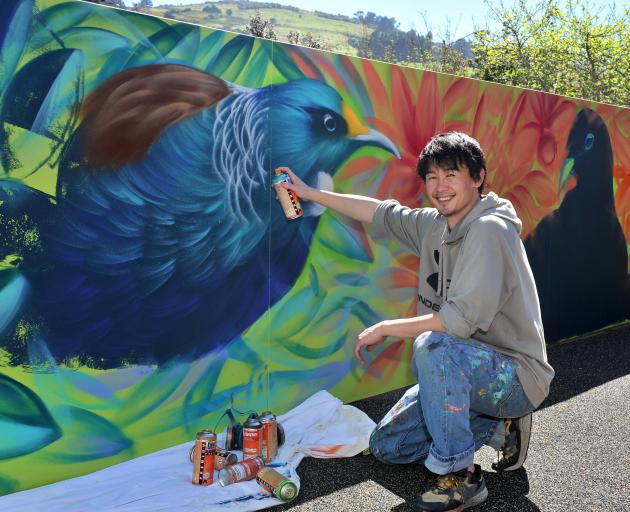 Applying the finer details to his latest mural at Ross Home & Hospital in Dunedin is street...