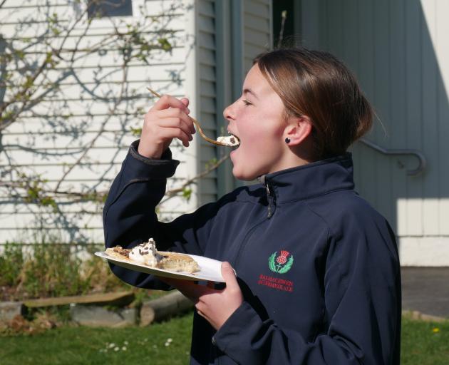 Balmacewen Intermediate pupil Lyla (13) takes a bite of the pancakes her class made to raise...