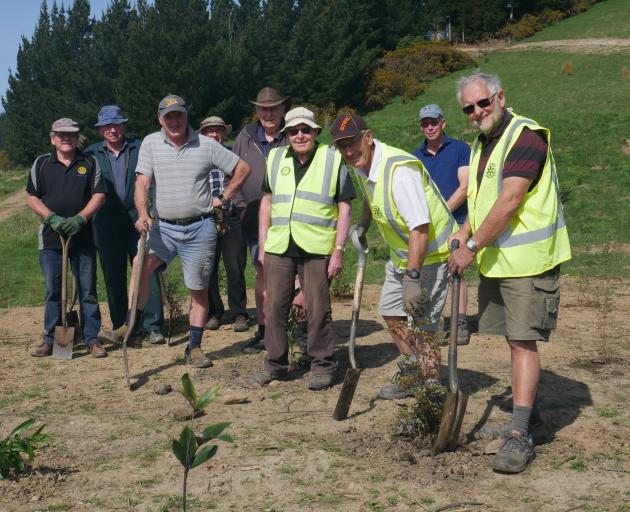 Rotary Club of Mosgiel members take a break after planting trees at AgResearch on Saturday.


