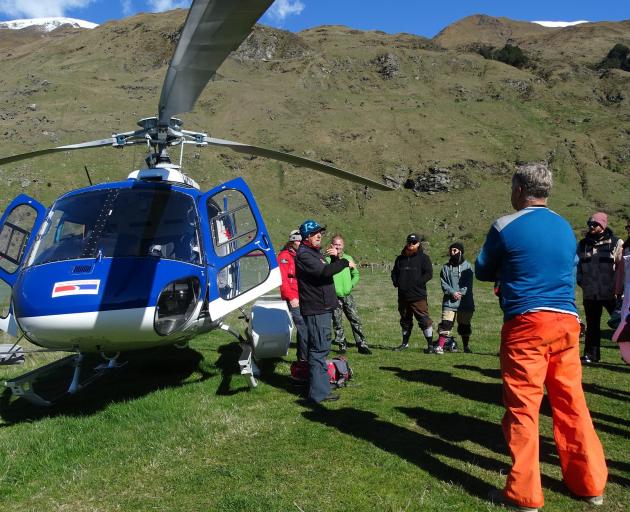 Chris Cochrane explains helicopter safety procedure to clients at the base of Treble Cone before...