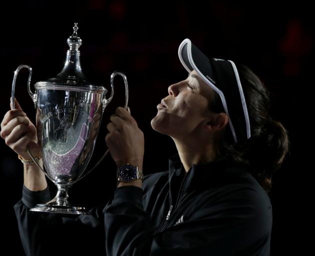 Spaniard Garbine Muguruza celebrates with the trophy after beating Estonian Anett Kontaveit to...