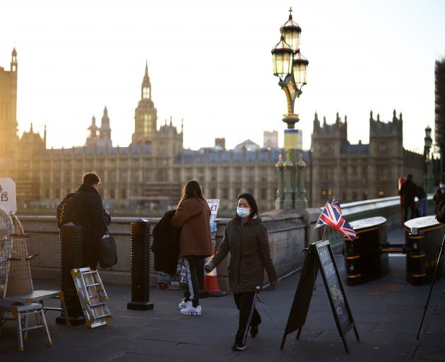 A person with face mask walks over Westminster Bridge in London. Photo: Reuters