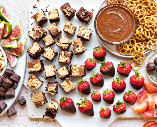 The ‘‘Chocolate deluxe’’ board consists of tahini swirl brownies, chocolate-dipped strawberries,...