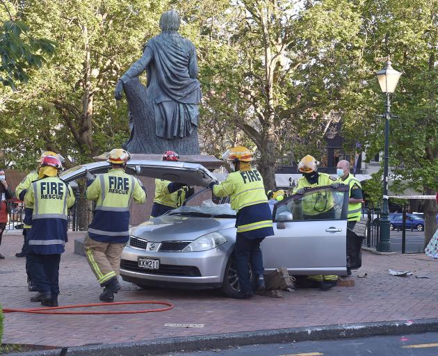 Emergency services remove a car roof to free an injured woman from a badly damaged vehicle in the...
