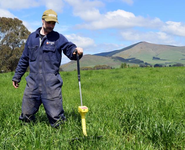 Westridge Farm owner Mark Anderson uses a plate meter to calculate the amount of pasture in a...