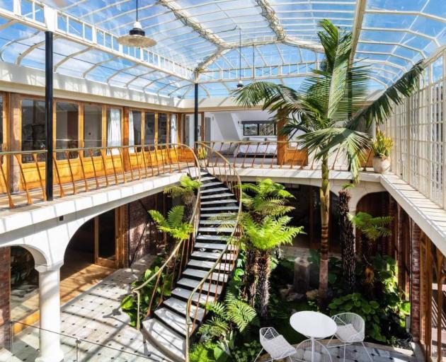 Spectacular glass conservatory and curved marble staircase. Photo: Supplied