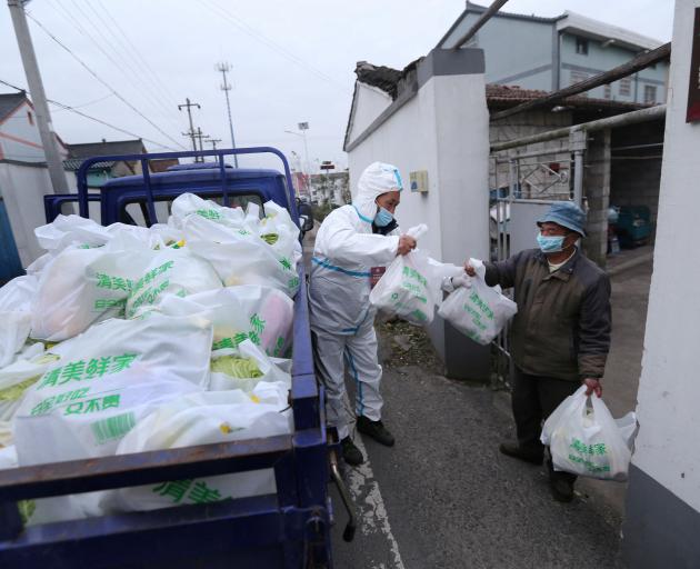 Volunteers deliver goods to locked-down residents in the Shangyu district of Shaoxing, Zhejiang...
