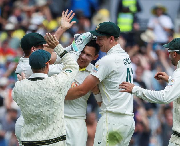 Scott Boland of Australia celebrates with teammates after taking his first test wicket, Mark Wood...