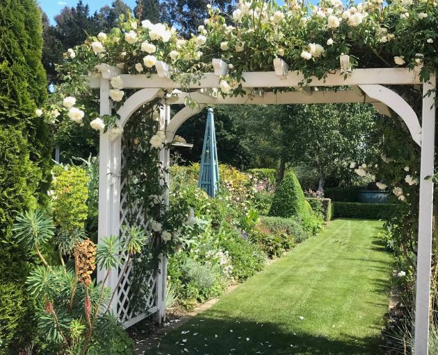 A rose-covered arch at Hawthorn Cottage.
