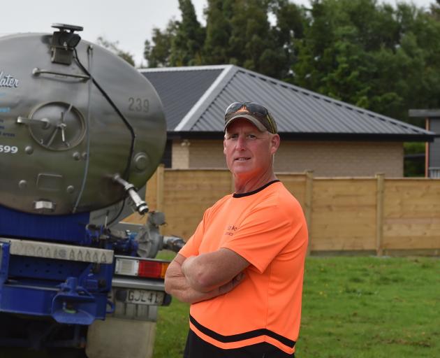 Waihola resident Bruce Pickering with a Clutha District Council-supplied water tanker. PHOTO:...