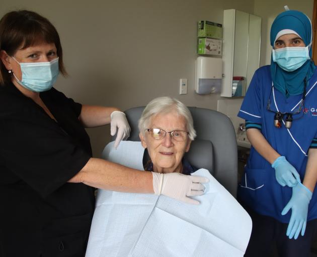 Oral health therapist Melissa McLellan, of Dunedin, fixes an apron around the neck of Bupa...