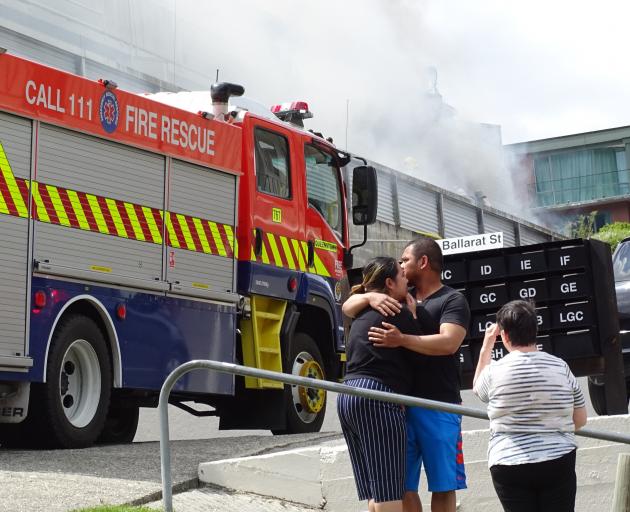 Nikki Gabriel and Rodel Musni embrace as their unit burns in the background. PHOTO: CASS MARRETT