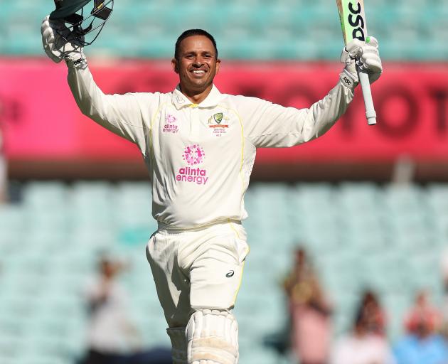 Usman Khawaja raises his bat after scoring back-to-back centuries in the fourth Ashes test at the...
